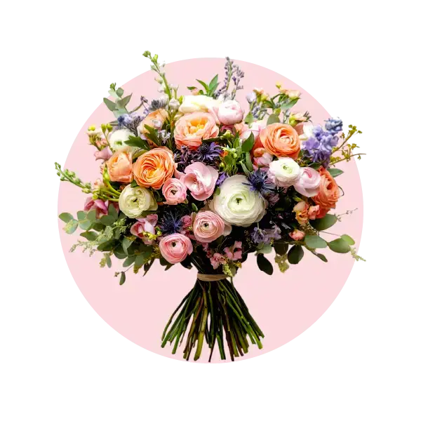 Vibrant bouquet of pastel flowers featuring roses and ranunculus on a pink background.
