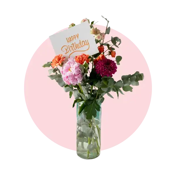 Vibrant birthday flower arrangement in a vase with a 'Happy Birthday' card, perfect for celebrations.