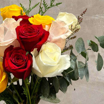 Vibrant bouquet of red, yellow, and white Ecuador roses with lush greenery, showcasing romance and elegance.