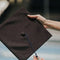 Graduation cap being held by hand, symbolizing achievement and celebration, perfect for graduation-themed flower arrangements.