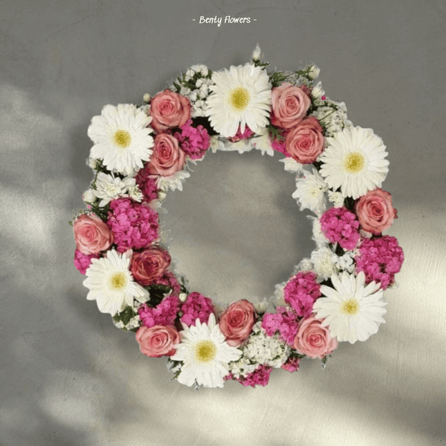 Memory Wreath featuring pink carnations, daisies, and greenery for condolences and remembrance.