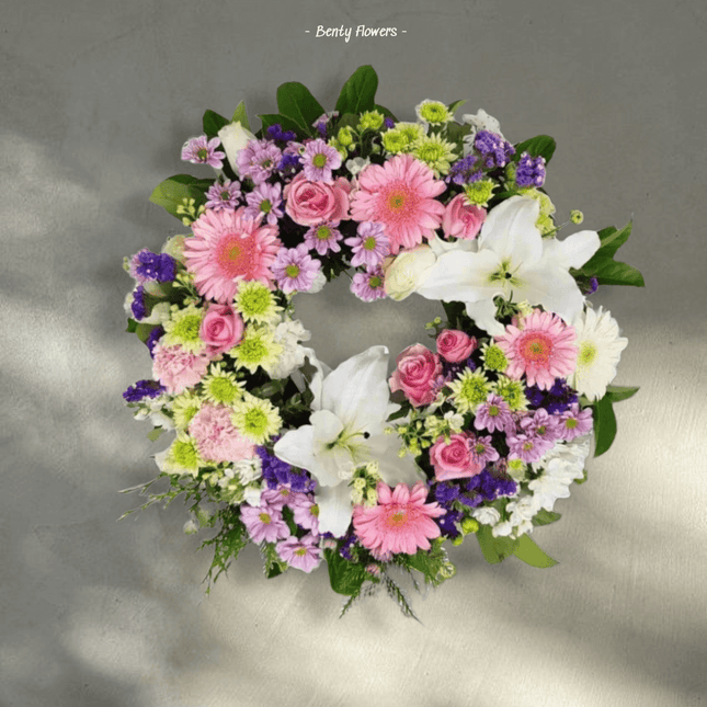 Gentle Circle wreath featuring pink roses, lilies, and vibrant flowers for serene condolences in Melbourne.