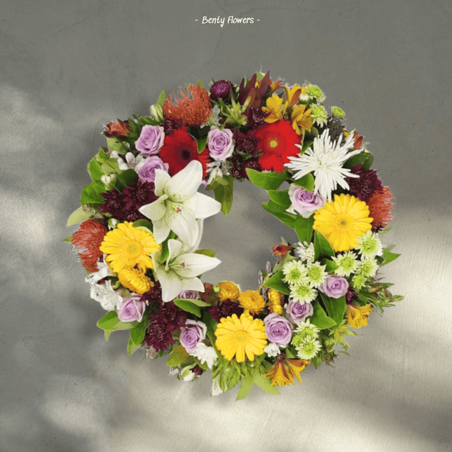 Harmony Tribute floral wreath featuring vibrant blooms in a circular arrangement, symbolizing love and remembrance.