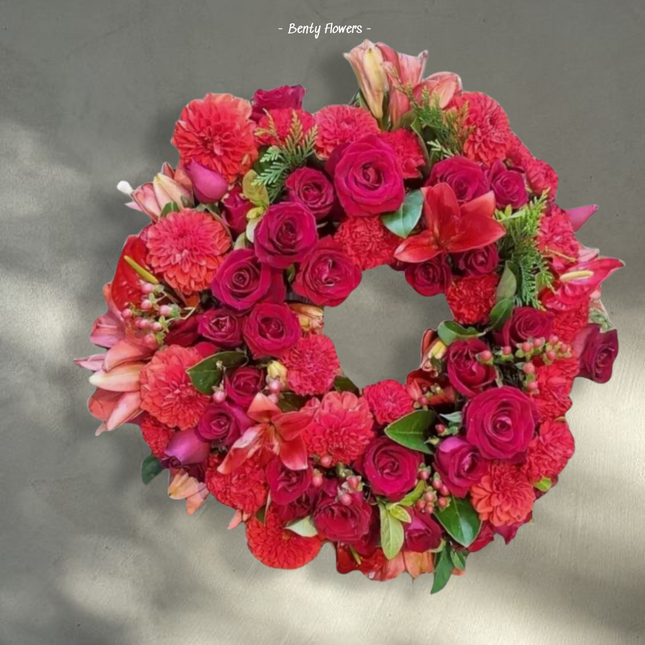 Radiant Remembrance – Bold Wreath with Red Roses, Lilies, and Carnations