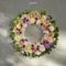 Grace Wreath featuring soft-toned roses and seasonal blooms, symbolizing sympathy and remembrance.