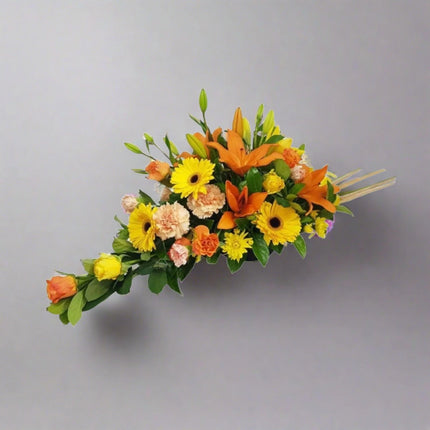 Autumn Radiance floral arrangement with orange lilies, yellow gerberas, peach roses, yellow chrysanthemums, and lush greenery