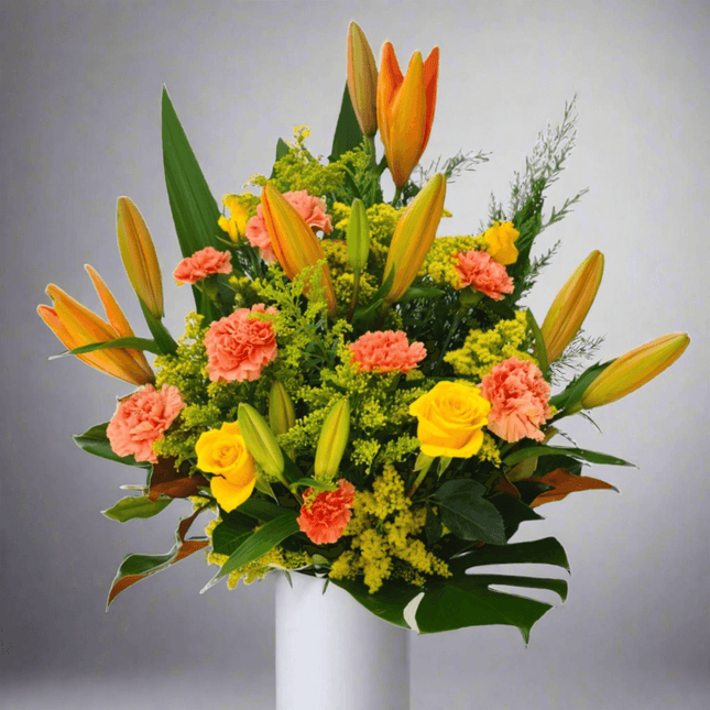 Vibrant Peach Harmony flower arrangement featuring orange lilies, yellow roses, and pink carnations in a classic box.