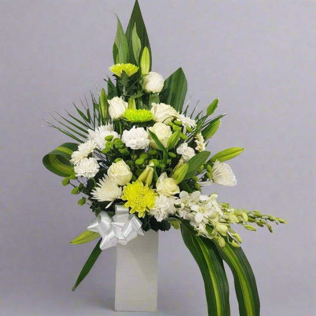 Elegant White Floral Arrangement with Lilies, Roses, and Greenery in a Tall Vase