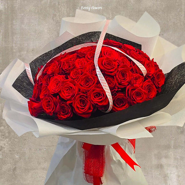 Bouquet of 60 premium red roses wrapped elegantly for Valentine's Day celebration.