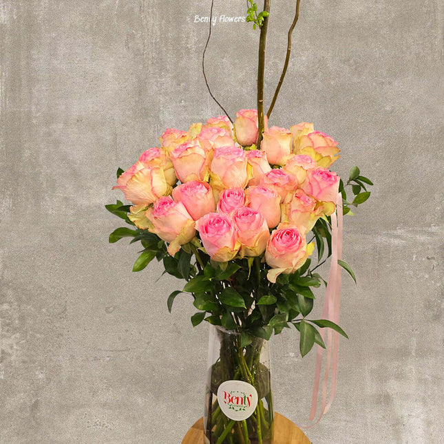 Elegant arrangement of pink roses in a glass vase, perfect for expressing love and beauty.