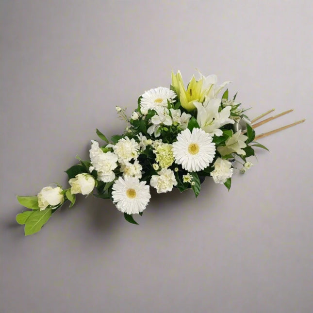 Pure Tranquility floral arrangement with white lilies, white roses, white gerberas, and lush greenery