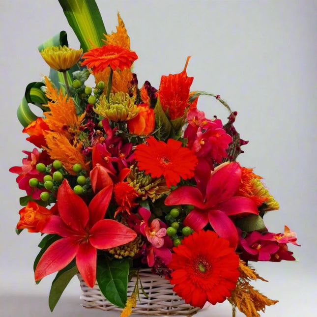 Fiery Fiesta – Vibrant Floral Basket with red lilies, orange gerberas, celosia, and hypericum berries.