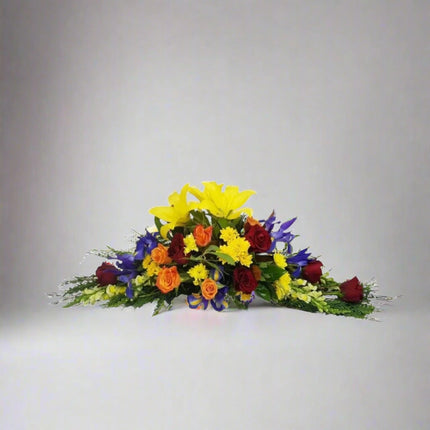 Tranquil Radiance bouquet with yellow lilies, red roses, orange roses, purple irises, and lush greenery