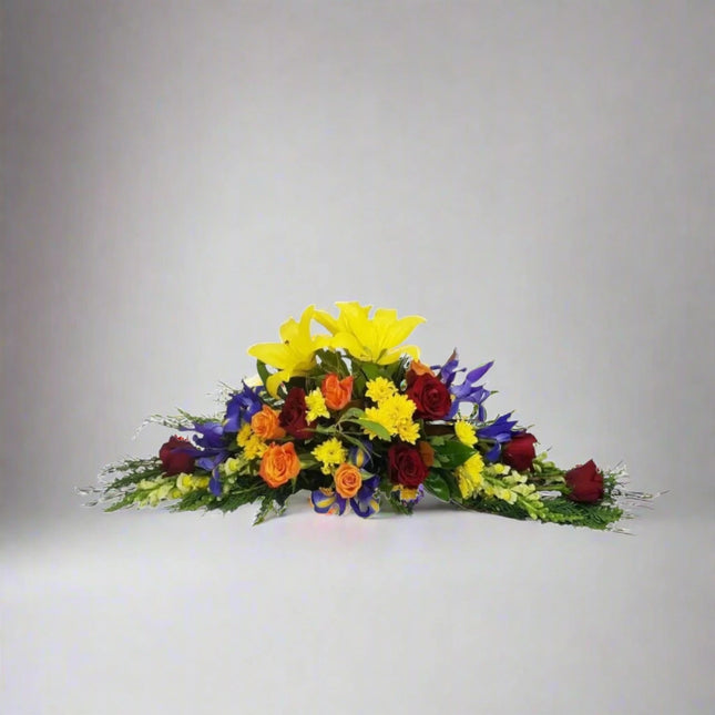 Tranquil Radiance bouquet with yellow lilies, red roses, orange roses, purple irises, and lush greenery