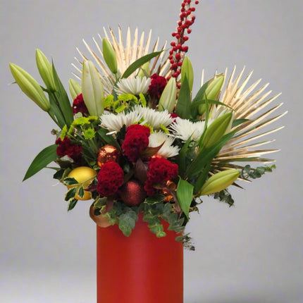 Festive Elegance – Holiday Floral Arrangement with white lilies, red celosia, chrysanthemums, and golden leaves.