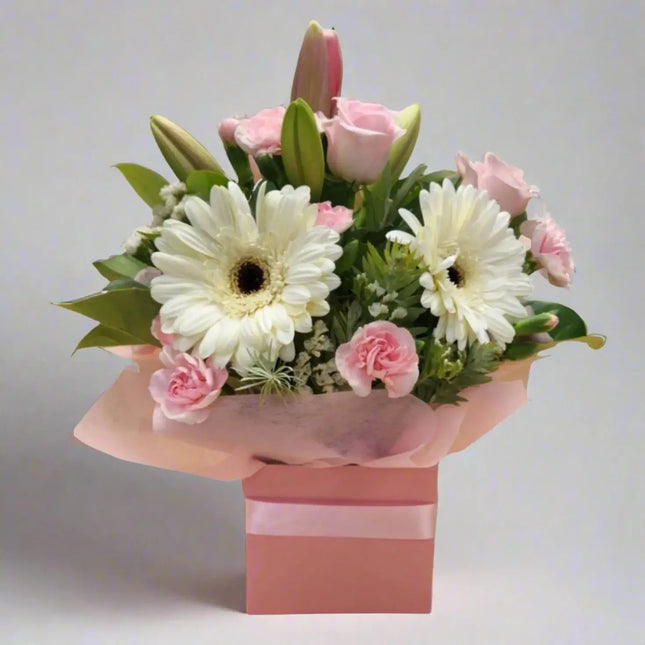Boxed flower arrangement featuring white daisies and pink roses in a modern gift box, perfect for gifting fresh blooms.