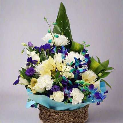 Ocean Breeze – Blue and White Floral Basket with blue orchids, white chrysanthemums, and cream roses.