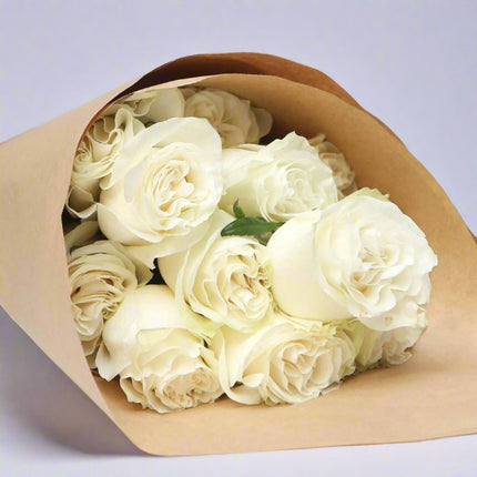 Pure Elegance – White Rose Bouquet wrapped in kraft paper.