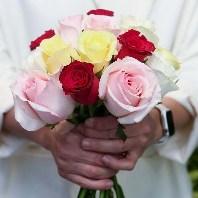 Rainbow Romance bouquet of pink, yellow, and red roses held in hands, perfect for celebrations in Melbourne.