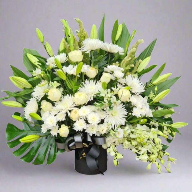 Eternal Peace standing spray with white lilies, cream roses, white chrysanthemums, and lush greenery