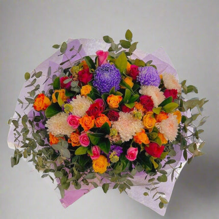 Vibrant Celebration – Colorful Floral Bouquet with purple chrysanthemums, orange roses, and pink gerberas.