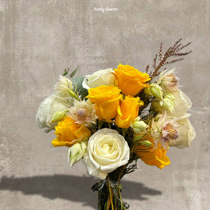 Vibrant yellow and white rose bouquet accented with soft pink blooms, elegantly arranged for special celebrations and thoughtful gifting.