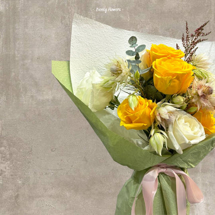 Vibrant yellow and white rose bouquet accented with soft pink blooms, elegantly arranged for special celebrations and thoughtful gifting.