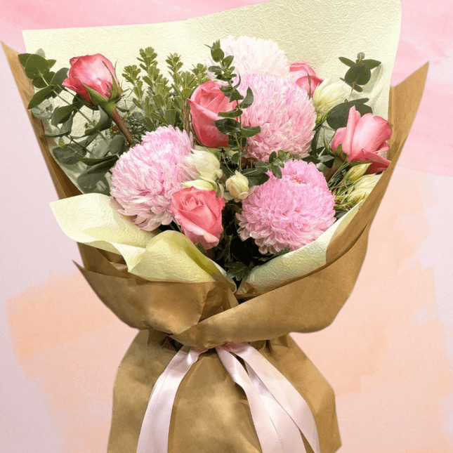 Beautiful bouquet of pink roses and chrysanthemums wrapped for birthday and anniversary celebrations.