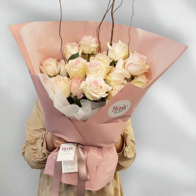 Bouquet of blush pink roses in elegant packaging, perfect for romantic occasions and expressing love.