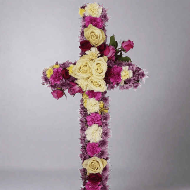 Heavenly Grace floral cross arrangement in pastel blooms honoring love and remembrance, ideal for funeral tributes.